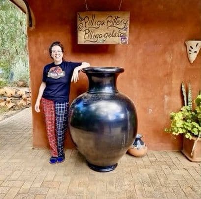 Cilla Russell beside a large black vessel at Pilliga Pottery