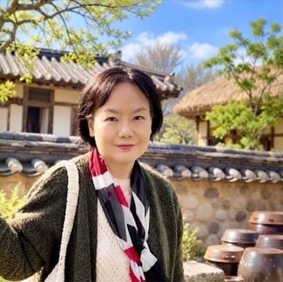 Sue Yoon in front of a traditional Korean hanok